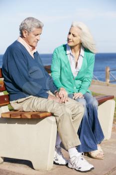 Senior Woman Comforting Depressed Husband Sitting On Bench