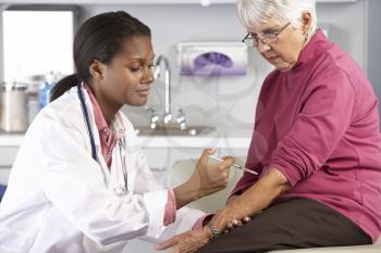 Doctor Giving Senior Female Patient Injection