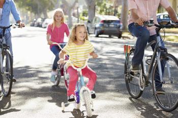 Family Cycling On Suburban Street