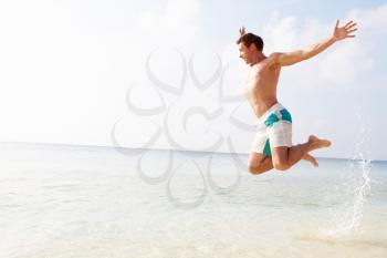 Man Jumping In The Air On Tropical Beach