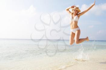 Woman Jumping In The Air On Tropical Beach