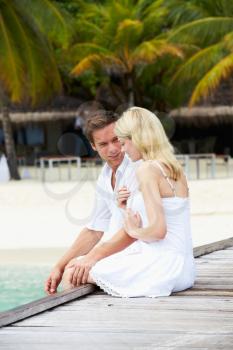 Couple Sitting On Wooden Jetty