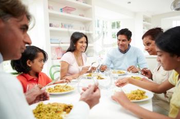 Multi Generation Indian Family Eating Meal At Home