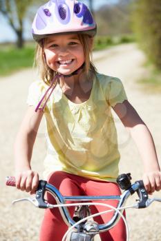 Young Girl Riding Bike Along Country Track