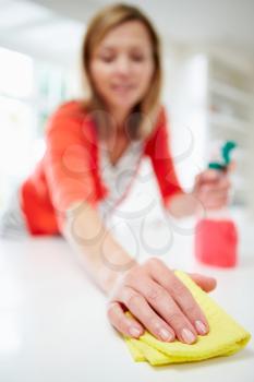 Woman Cleaning Surface In Kitchen