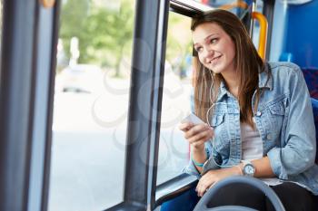 Teenage Girl Wearing Earphones Listening To Music On Bus