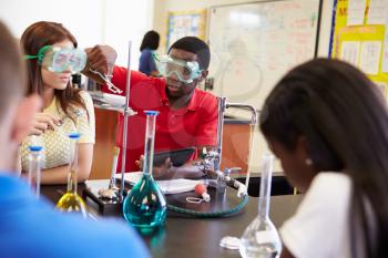 Pupils Carrying Out Experiment In Science Class