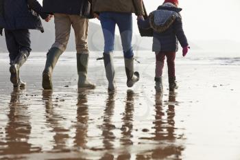 Close Up Of Family Walking Along Winter Beach