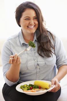 Overweight Woman Eating Healthy Meal Sitting On Sofa