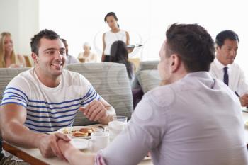 Male Couple Enjoying Breakfast In Hotel Restaurant