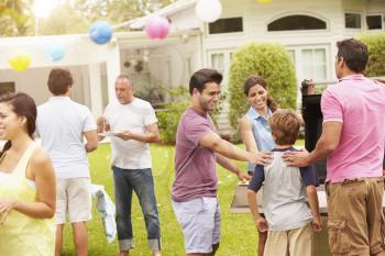 Multi Generation Family Enjoying Party In Garden Together