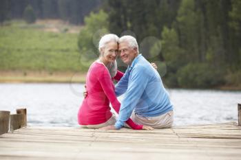 Romantic senior couple sitting on a jetty