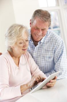Senior couple using tablet at home