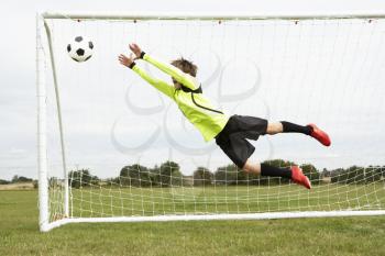 Boy goalkeeper jumping to save goal