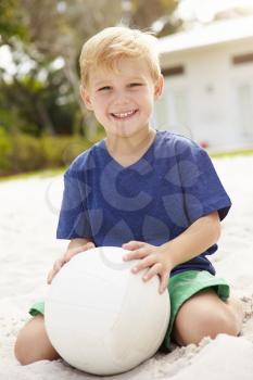 Young Boy Playing Game Of Volleyball In Garden