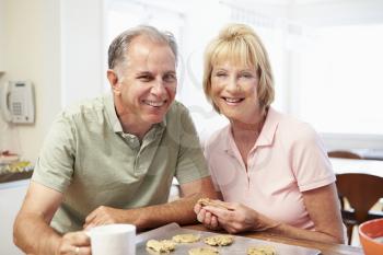 Senior Woman With Husband Baking Cookies In Kitchen