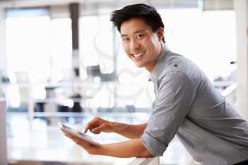 Portrait of young man using tablet in office