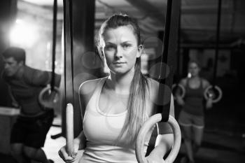 Black And White Shot Of Woman Using Gymnastic Rings In Gym