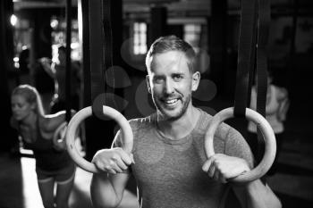 Portrait Of Man In Gym Exercising With Gymnastic Rings