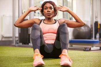 Young woman doing crunches in a gym