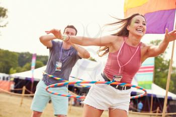 Woman with hula hoop at a music festival, man in background