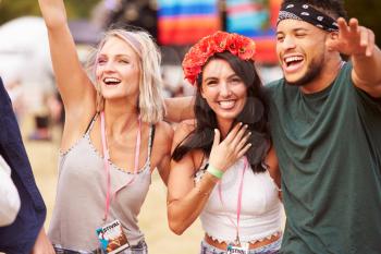 Three friends in the audience at a music festival