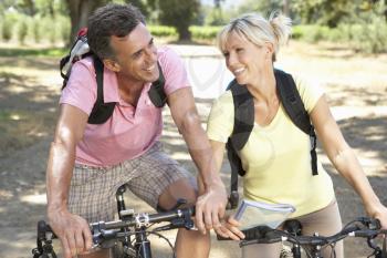 Middle Aged Couple Cycling Through Countryside