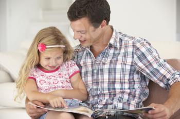 Father And Daughter Reading Book At Home