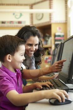 Elementary School Pupil With Teacher In Computer Class