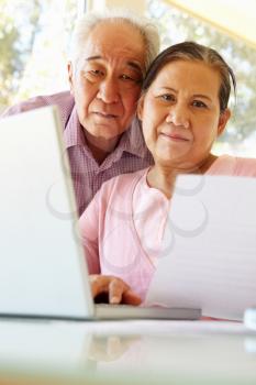 Senior Taiwanese couple working on laptop