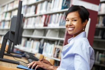 Woman working on computer in library