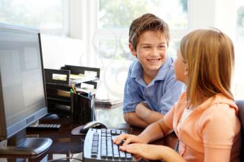 Young boy and girl using computer at home