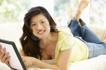 Asian woman using tablet at home