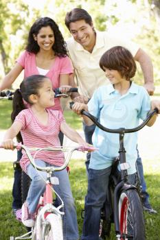 Young Hispanic Family Cycling In Park