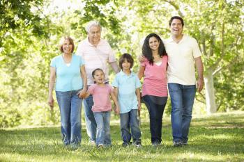 Multi Generation Hispanic Family Walking In Park
