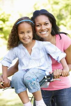Young African American Mother And Daughter Cycling In Park