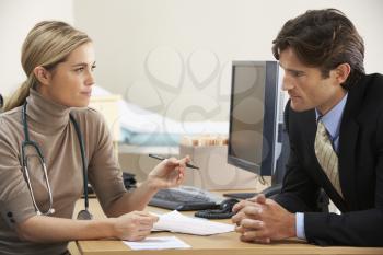 Female Doctor talking to businessman patient