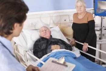 Doctor talking to senior couple in hospital