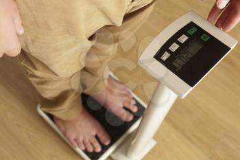 Man standing on digital scales cropped waist down