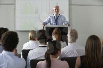 Middle Aged Businessman Delivering Presentation At Conference