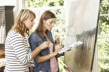 Female Artist Teaching Pupil In Studio