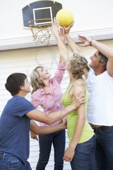Teenage Family Playing Basketball Outside Garage