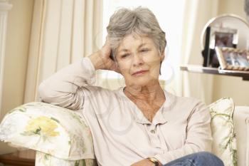 Unhappy Retired Senior Woman Sitting On Sofa At Home