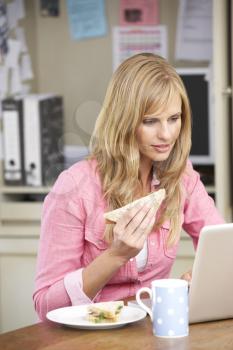 Woman Having Working Lunch In Home Office