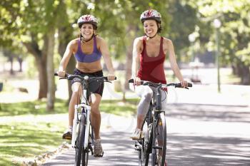 Two Women Cycling Through Park