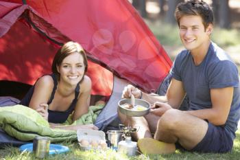 Young Couple Cooking Breakfast On Camping Holiday