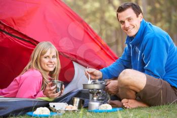 Couple Cooking Breakfast On Camping Holiday