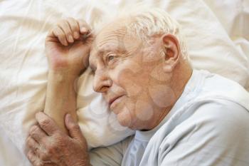 Senior Man Relaxing In Bed