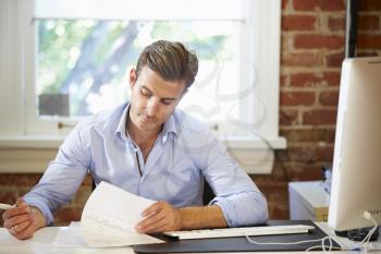 Man Working At Desk In Contemporary Office