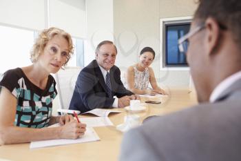 Four Businesspeople Having Meeting In Boardroom